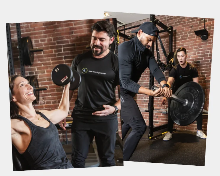 Two people do different weight training exercises at a gym with trainers providing on-site personal training; the setting features brick walls and gym equipment.